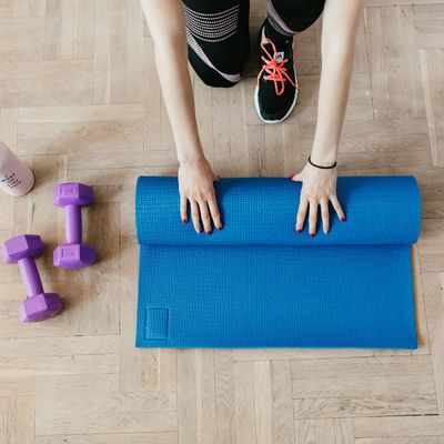 A neatly rolled yoga mat on a wooden floor.